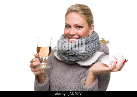 Junge Frau hat den Schnupfen mit Tee bekämpft und hält froh das letzte Taschentuch hoch Stock Photo