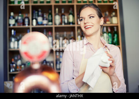 Waitress cleaning glasses at the bar counter Stock Photo