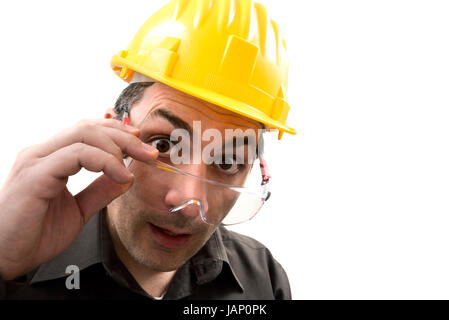 engineer with glasses and a helmet, watch in amazement straight in front of himself Stock Photo