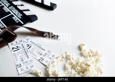 Closeup of movie tickets with popcorn and reels decoration on white table Stock Photo