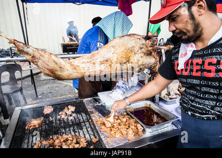 Kuala Lumpur, Malaysia. 7th June, 2017. A visit to the Bangsar Ramadan food bazaar in Kuala Lumpur, where people come to buy halal food for their breaking of fast in the evening. A stall seller preparing roast lamb at the Ramadan food bazaar. Credit: Danny Chan/Alamy Live News Stock Photo