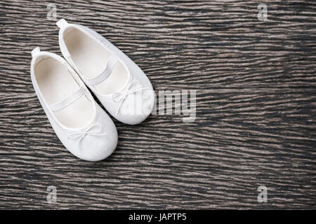 White baby shoe on wooden background , top view Stock Photo
