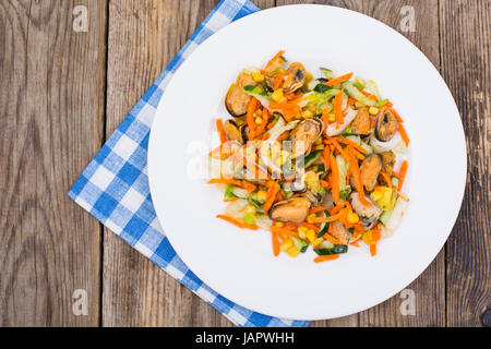 Peking cabbage, corn, cucumber, mussels on a white saucer on an  Stock Photo