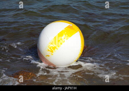 White-yellow swimming buoy in the surf Stock Photo
