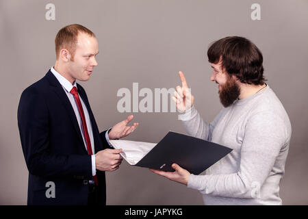 Business negotiations. Salesman and buyer discuss the contract standing in front of each other isolate on dark background. Stock Photo