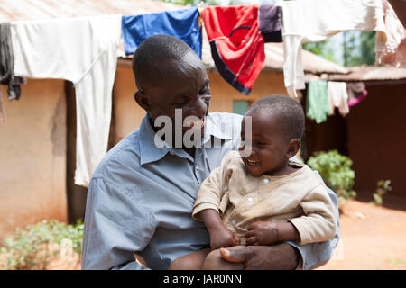 A father and child outside their hut, Kenya, Africa Stock Photo