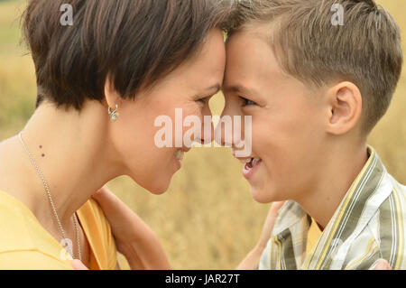 Mother and son standing face to face outdoors Stock Photo
