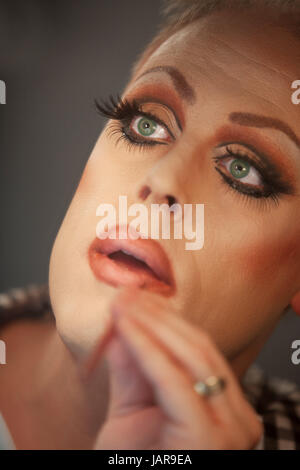 Close up of drag queen putting on lipstick Stock Photo