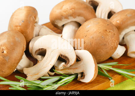 Fresh cremini mushrooms on cutting board Stock Photo