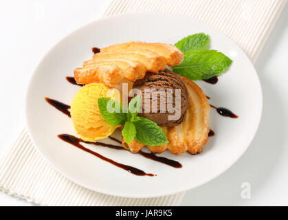 Two scoops of ice cream with puff pastry biscuits Stock Photo