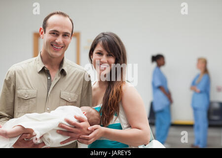 Smiling couple holding a new born baby in a hospital Stock Photo