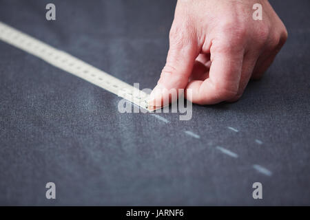 Tailors Hand Measuring Fabric on Table Stock Photo