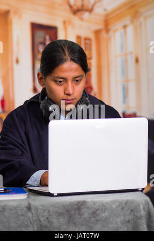 Close up portrait of smiling indigenous young latin man using laptop with headphones Stock Photo