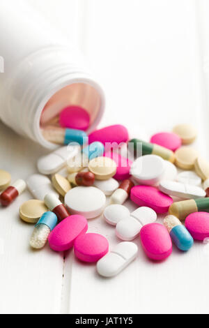 colorful pills spilled from medical bottle Stock Photo