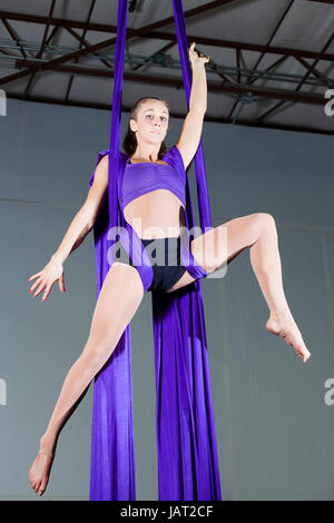 Beautiful woman gymnast performing aerial exercises Stock Photo