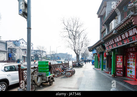 BEIJING, CHINA - MARCH 19, 2017: people, restaurant and parking lots on Liangshidian street in Dashilanr business area, on south of Tiananmen Square,  Stock Photo