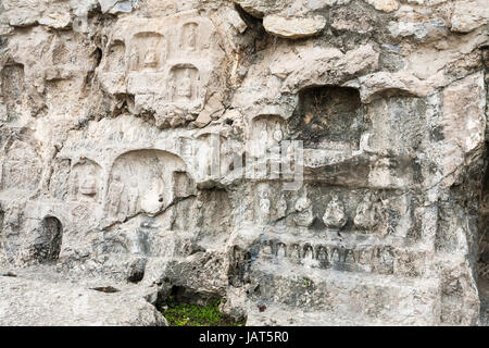 LUOYANG, CHINA - MARCH 20, 2017: carved slope of West Hill of Chinese Buddhist monument Longmen Grottoes. The complex was inscribed upon the UNESCO Wo Stock Photo