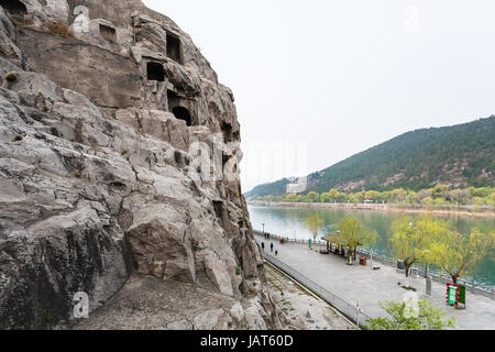 LUOYANG, CHINA - MARCH 20, 2017: above view of waterfront with tourists in Chinese Buddhist monument Longmen Grottoes. The complex was inscribed upon  Stock Photo