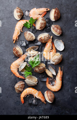 Fresh seafood on stone table. Scallops and shrimps. Top view Stock Photo