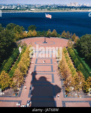 Liberty Island, NY, USA - October 1990: Visitors stroll on plaza in the shadow of the Statue of Liberty Stock Photo