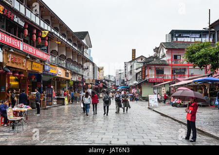 YANGSHUO, CHINA - MARCH 30, 2017: tourists on shopping street in Yangshuo city in spring. Town is resort destination for domestic and foreign tourists Stock Photo