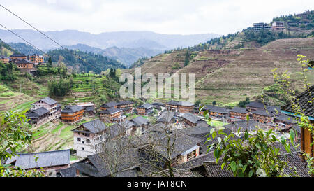 travel to China - above view of Dazhai village in mountain valley on green hills in area Longsheng Rice Terraces (Longji Rice Terraces) in spring Stock Photo