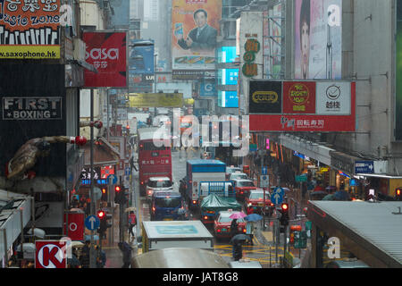 Rain, signs and traffic congestion on Sai Yeung Choi Street, Mong Kok, Kowloon, Hong Kong, China Stock Photo