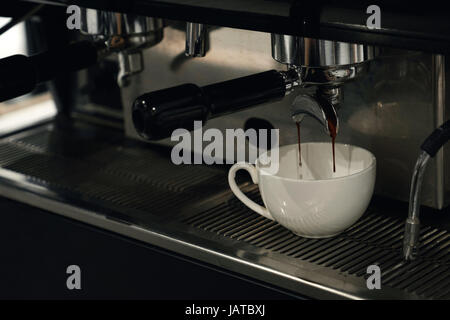 Coffee pouring from coffee in a white up. Horizontal photo Stock Photo