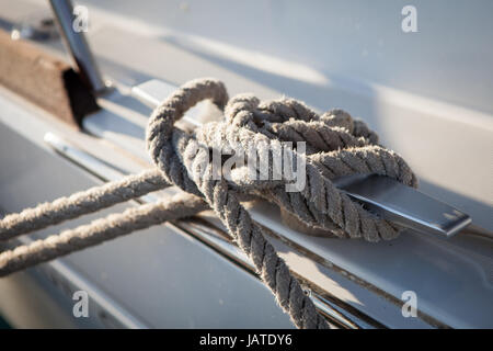 White mooring rope tied around steel anchor on boat or ship Stock Photo