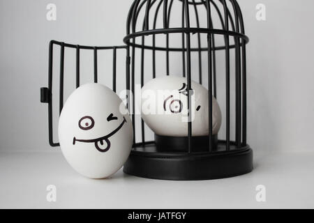 Eggs with painted face. Photo for your design. two eggs. Egg in a cage Stock Photo