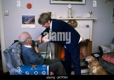 District Nurse on a home visit taking an elderly man's blood pressure Stock Photo