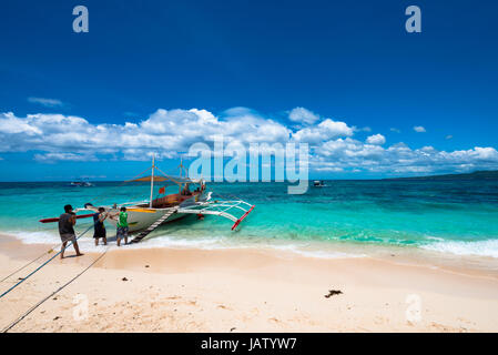 Boat at Puka Beach at the northern end of Barocay Island in the Visayas region of Philippines. Local men brings lots of tourists everyday. Stock Photo