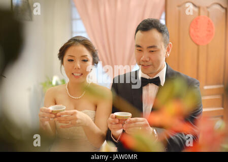 Traditional Chinese wedding, bride and groom serving tea in ceremony. Stock Photo