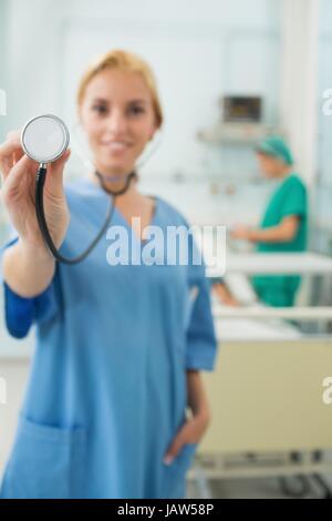 Focus on a blonde nurse holding a stethoscope Stock Photo