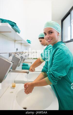 Nurse washing hands while smiling Stock Photo