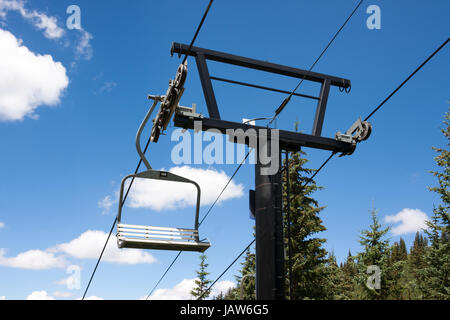 Empty ski lift seats in alpine summer landscape Stock Photo