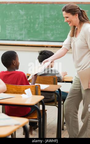 Teacher collecting her students exercise books Stock Photo - Alamy