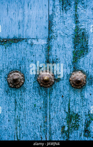 Steel studs in a weathered blue timber door in the Andes mountains. Stock Photo