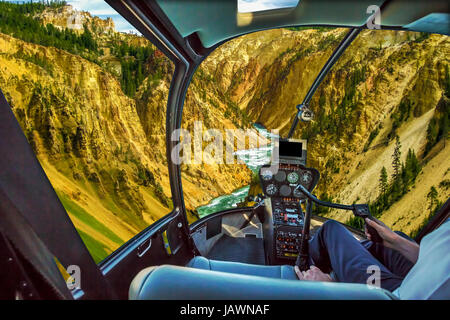 Helicopter cockpit pilot arm flight over Lower Falls, most popular waterfall in Yellowstone, located in head of Grand Canyon in Yellowstone River of Y Stock Photo