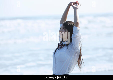 Young Japanese woman in a high school uniform by the sea, Chiba, Japan Stock Photo