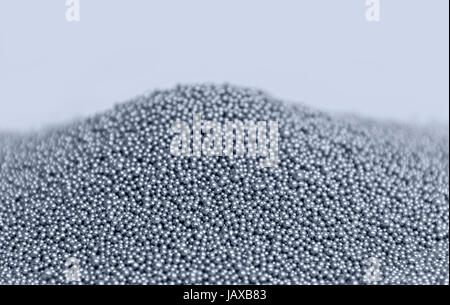 pile of silver metallic beadlets in light back, blue toned Stock Photo