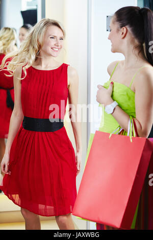 Portrait of a happy girl looking at her friend in clothing department Stock Photo