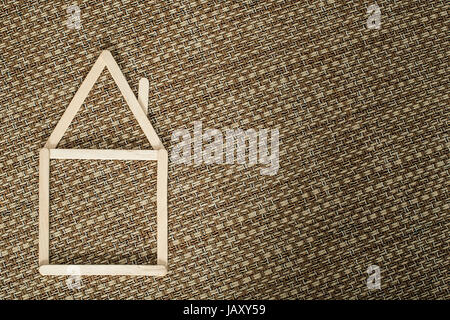 Model house made of wooden sticks placed in room interior. Stock Photo