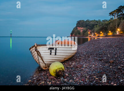 Boats on the red sanded beach at Shaldon in Devon at night. Stock Photo