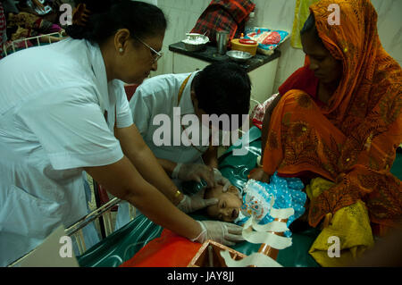 Doctor treating an infant at the “International Centre for Diarrhoeal Disease Research, Bangladesh”, ICDDR’B, popularly known as “Cholera Hospital”.   Stock Photo