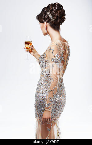 Elegant Woman in Silver-Golden Dress holding Wineglass of Champagne. Luxury