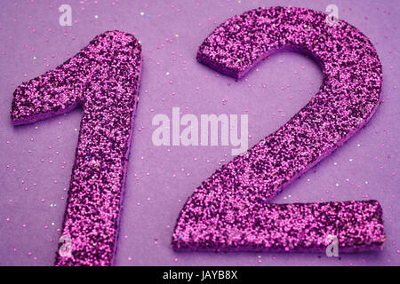 Number twelve purple color over a purple background. Anniversary. Horizontal Stock Photo