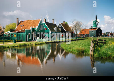 Authentic Zaandam mills and traditional vibrant houses on the water canal in Zaanstad village, Zaan river, Netherlands Stock Photo