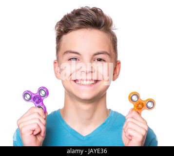 Young teen boy holding popular fidget spinner toy - close up portrait. Happy smiling child playing with Spinner, isolated on white background. Stock Photo