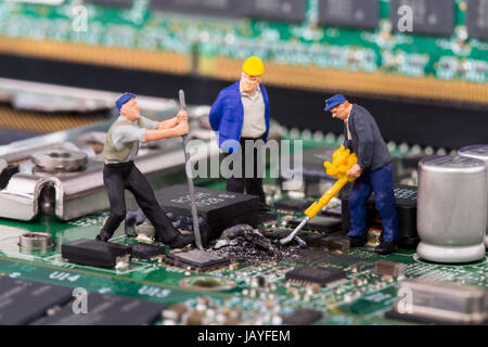 miniature workers on a computer mainboard - studio shot Stock Photo